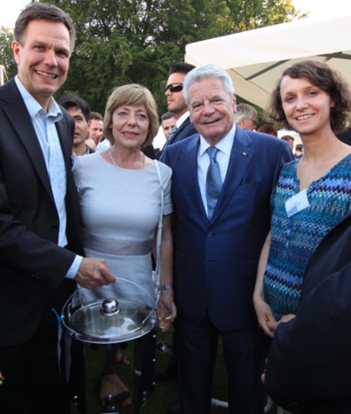 „Endlich mal was Praktisches“, sagte der damalige Bundespräsident Joachim Gauck (81, 2. von rechts, parteiloser evangelisch-lutherischer Pastor aus Rostock, Bundespräsident von 2005 bis 2017), als ihm und seiner fränkischen Freundin Daniela Schadt (61, 2. Von links, Journalistin) der atmosfair-Gründer Dr. Dietrich Brockhagen (54, links) aus Berlin und Projektmanagerin Julia Hoffmann (rechts) auf der Woche der Umwelt im Juni 2016 auf Schloss Bellevue den Save80 vorstellten. Das ist ein rauchvermindernder Mittagessen-Ofen, der von der gemeinnützigen Klimaorganisation atmosfair gGmbH aus Berlin Kreuzberg mitentwickelte wurde und in Ruanda massenhaft zum Einsatz kommt © Newsletter-Foto atmosfair gGmbH