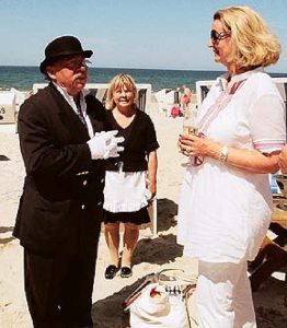 Butler John und Assistentin Helga Hansen am 1. Juli 2010 bei einem Champagnerempfang am Strand von Kampen im Gespräch mit der Juwelierin Christel Heilmann (75) aus Mettmann-Metzkausen bei Düsseldorf. Christel Heilmanns Düsseldorfer Freundinnen hatten die Überraschungs-Geburtstagsparty zum 64. Geburtstag von Christel Heilmann mit Butler John geplant © vivasylt.com/aktuelles