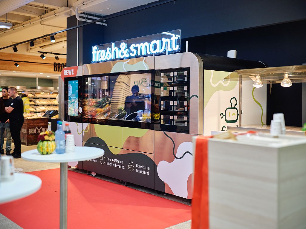 Großer Andrang beim Launch des CA-1 in einem Rewe-Supermarkt in Düsseldorf. Innerhalb weniger Minuten werden hier Gerichte in gleichbleibend hoher Qualität hergestellt und an die Kunden und Kundinnen ausgegeben. @ Philipp Löffler